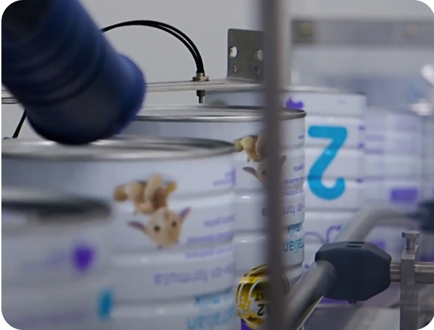 Cans of Aussie Bubs formula being sealed in a factory